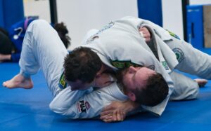 Two men training brazilian jiu jitsu in side control position